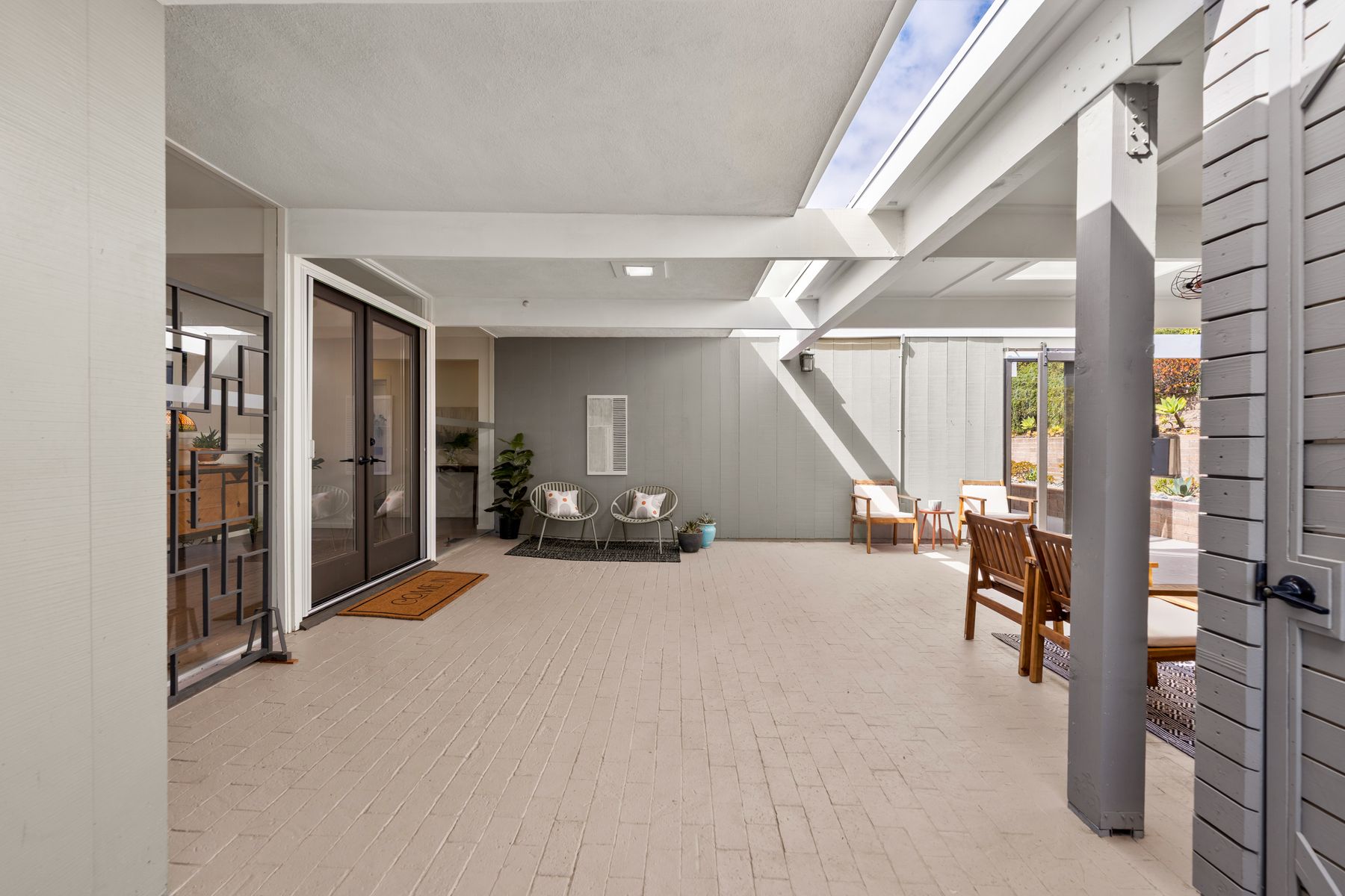 Sheltered courtyard with exposed beams, skylights and seating